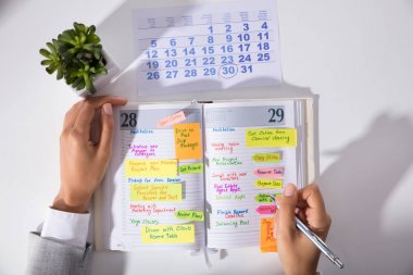İşkadını el takvim yazma programı Diary ile yükseltilmiş görünümünü ofiste masa