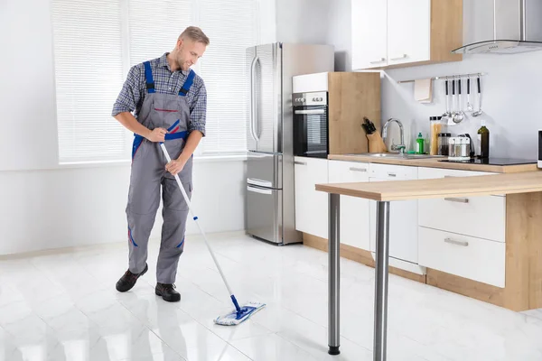 Happy Young Male Worker Mopping Floor Mop Kitchen — стоковое фото