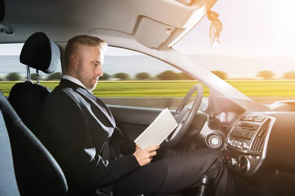 Junger Geschäftsmann Sitzt Selbstfahrendem Auto Und Liest Buch — Stockfoto