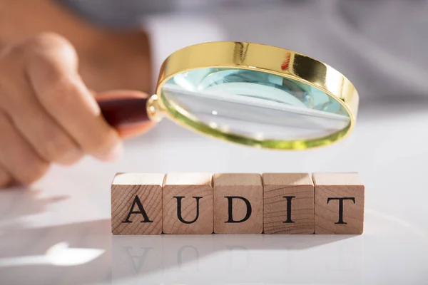 Person Examining Audit Blocks Magnifying Glass White Desk — Stock Photo, Image