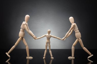 Ahşap şekil gri arka plan üzerinde birbirlerine karşı çekerek çocuk kukla ebeveynler