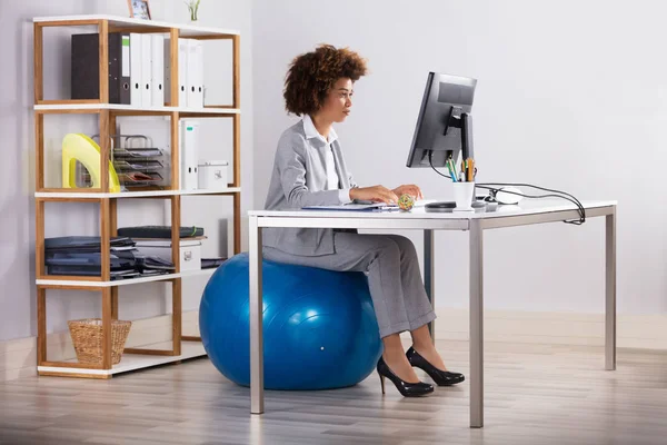 Geschäftsfrau Sitzt Auf Fitnessball Und Arbeitet Computer — Stockfoto