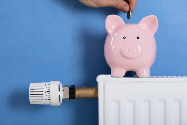 Close Van Persoon Man Munt Invoegen Piggy Bank Gehouden Radiator — Stockfoto