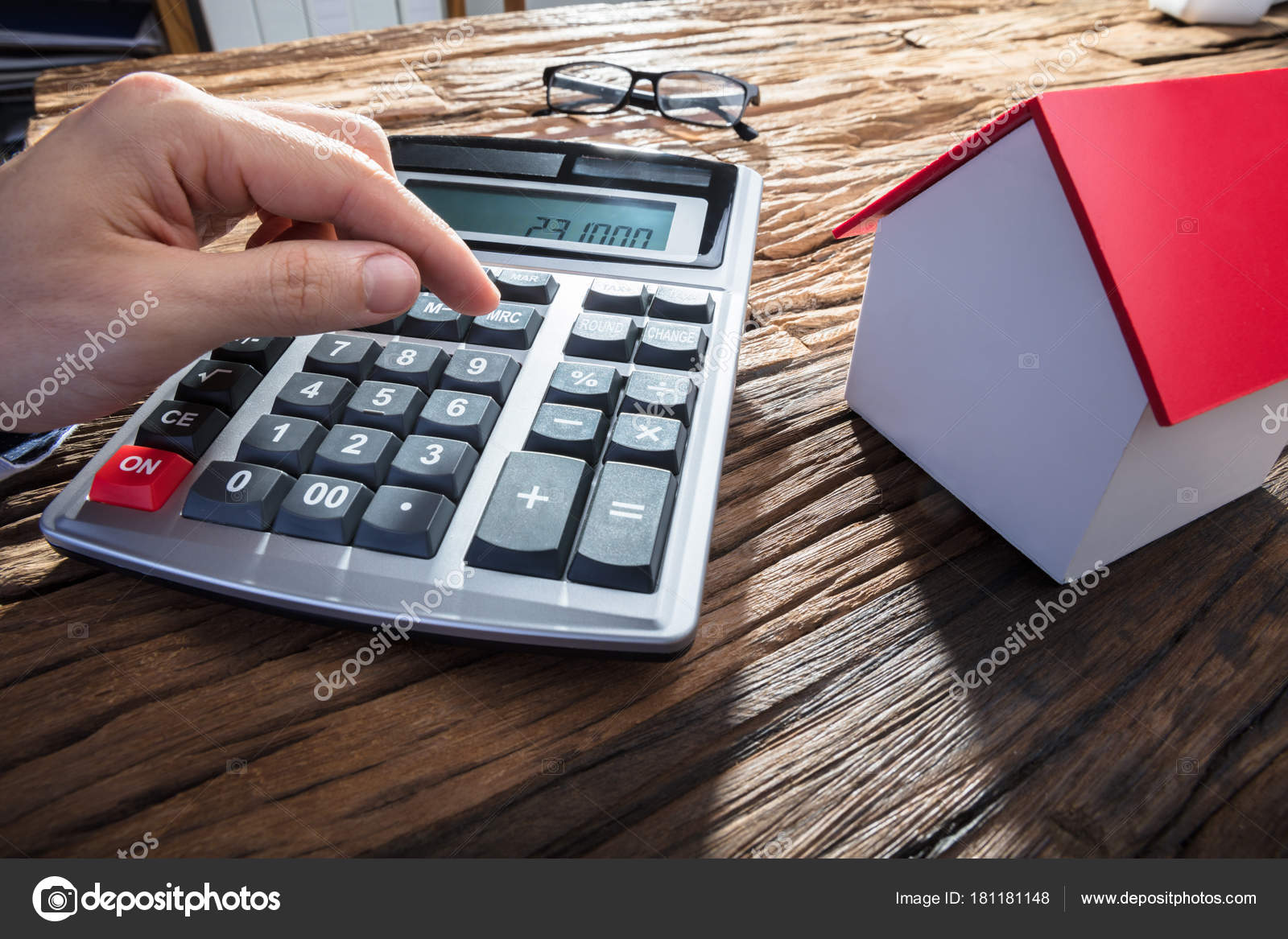 Bureau Avec Maison : Main personne aide calculatrice avec maison modèle sur bureau bois