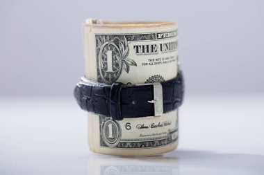 Rolled Up Dollar Banknote Tied With Belt Against White Background clipart