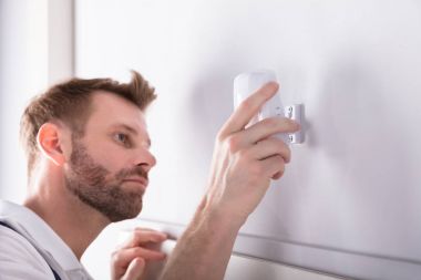Güvenlik sistemi kapı sensör duvara yükleme genç erkek elektrikçi Close-Up