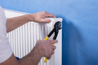 Radyatör İngiliz anahtarıyla yükleme bir insan eli Close-Up