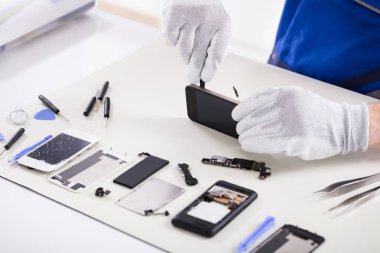Close-up Of A Human Hand Repairing Smartphone With Screwdriver