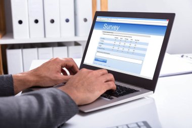 Yakın çekim bir işadamının'ın el laptop Office Online Anket Formu doldurma
