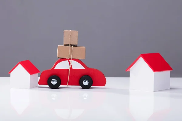 Red Car Transporting Cardboard Boks One House Another White Desk — Stok Foto