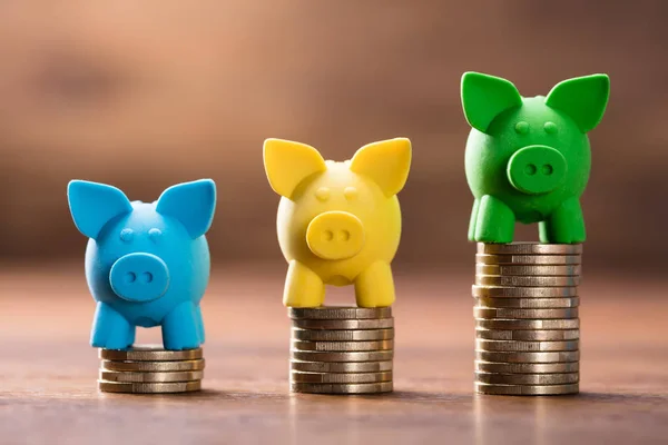 Fila Piggybank Colorido Pilha Moedas Crescente Sobre Mesa Madeira — Fotografia de Stock