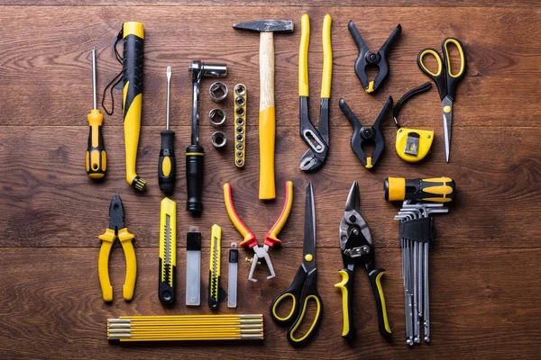 Ahşap masa üzerinde düzenlenen birçok sarı onarım araçları havai görünümü