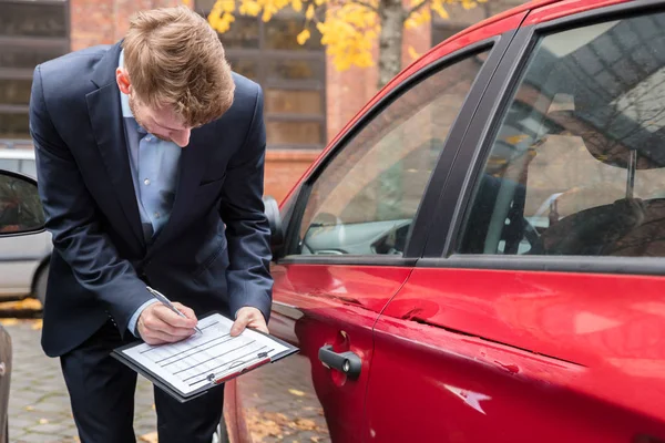 Agente Seguros Escrevendo Área Transferência Enquanto Examina Carro Após Acidente — Fotografia de Stock