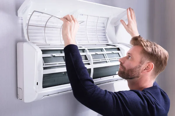 Close Young Man Checking Air Conditioner Mounted Wall — Stock Photo, Image