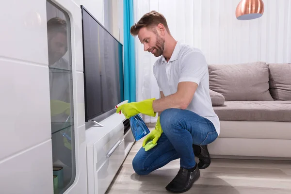 Hombre Joven Con Guantes Que Limpian Los Muebles Con Botella —  Fotos de Stock