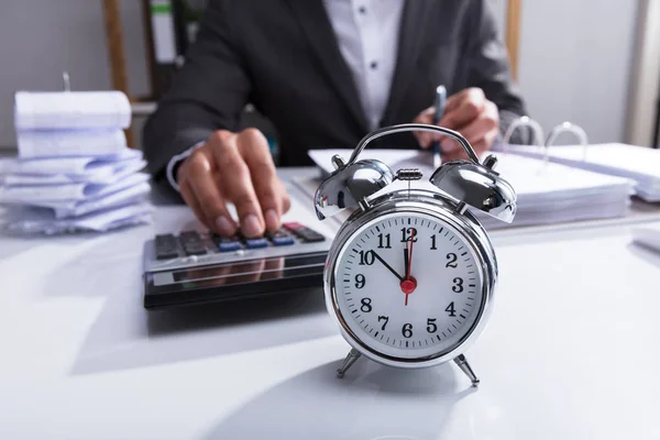 Businessperson Using Calculator Calculating Bill Alarm Clock Desk — Stock Photo, Image