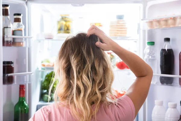 Visão Traseira Uma Mulher Confusa Que Olha Refrigerador Aberto Casa — Fotografia de Stock