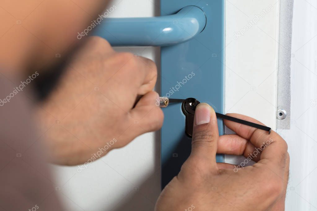 Close-up Of A Person's Hand Opening Door Lock With Lockpicker