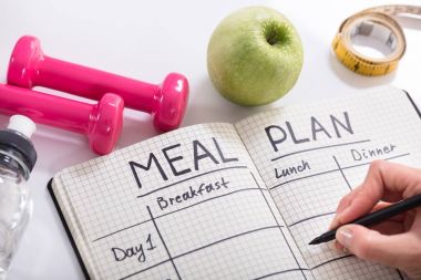 Yemek planı defter ahşap masa dolduran kişi el yüksek açılı görünüş