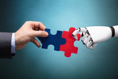 İşadamı ve Jigsaw tutan Robot turkuaz arka plan üzerinde bulmaca