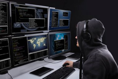 Arkadan görünüş bir hacker Office veri çalmak için birden fazla bilgisayar kullanma