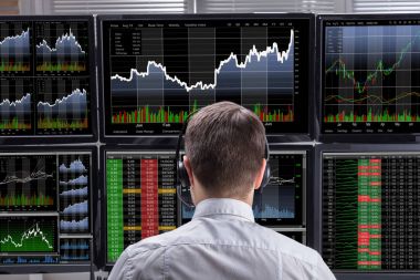 Grafikler birden çok bilgisayar ekranlarında analiz bir genç erkek borsa Broker yan görünüm