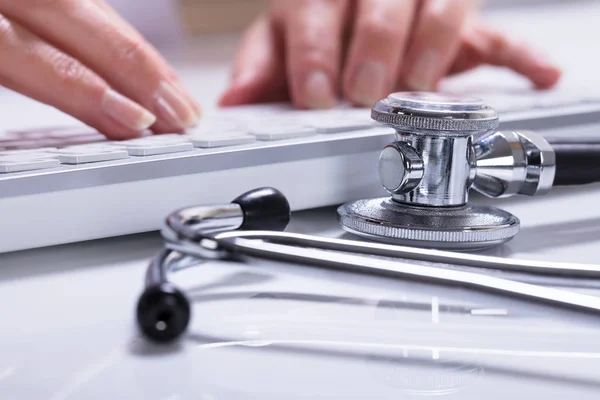 Close Woman Hand Typing Stethoscope Desk — Stock Photo, Image