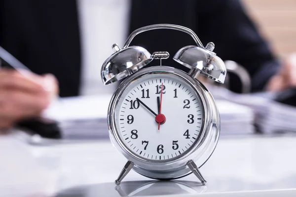 Geschäftsmann Arbeitet Büro Mit Uhr Und Gestapelten Ordnern Auf Dem — Stockfoto