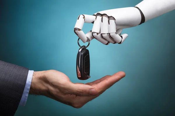 Nahaufnahme Eines Roboters Der Einem Geschäftsmann Autoschlüssel Auf Grauem Hintergrund — Stockfoto