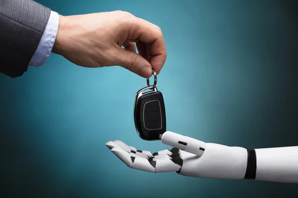 Robot Gri Arka Plan Üzerinde Araba Anahtarı Veren Bir Işadamının — Stok fotoğraf