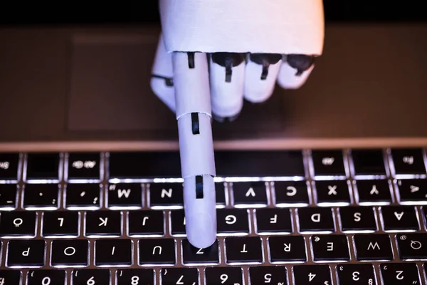Close-up Of A Robot\'s Hand Typing On Laptop