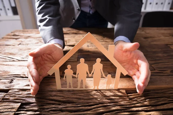 Modelo Casa Proteção Mão Empresário Papel Família Cortados Mesa Madeira — Fotografia de Stock