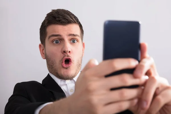Nahaufnahme Eines Glücklichen Jungen Geschäftsmannes Der Auf Sein Smartphone Blickt — Stockfoto