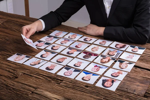 Businessperson Hand Choosing Photograph Candidate Wooden Desk — Stock Photo, Image