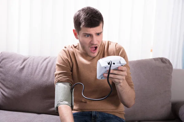 Joven Sorprendido Midiendo Presión Arterial Casa —  Fotos de Stock