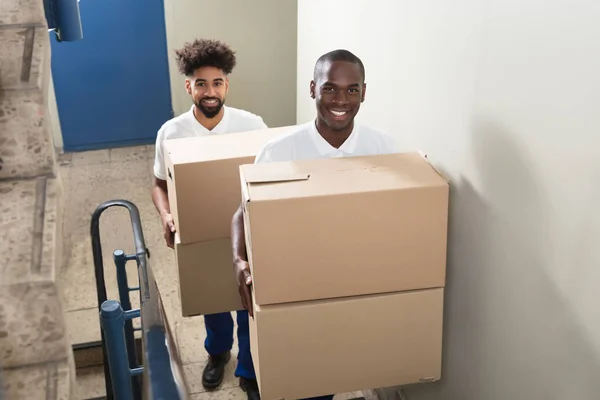 Portrait Two Young Smiling Movers Standing Staircase Holding Cardboard Boxes — Stock Photo, Image