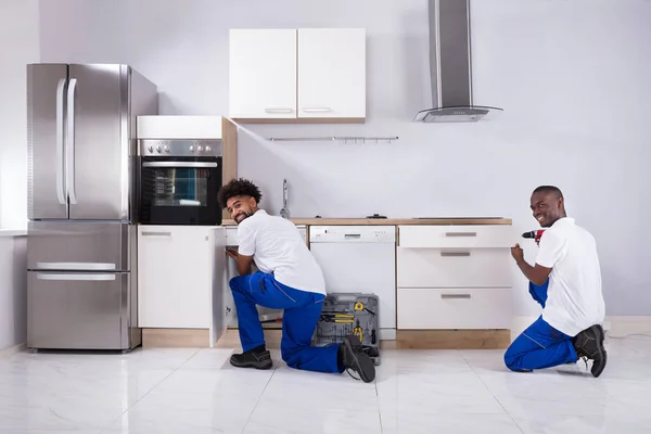 Visão Traseira Dois Jovens Faz Tudo Uniforme Fixando Armários Madeira — Fotografia de Stock