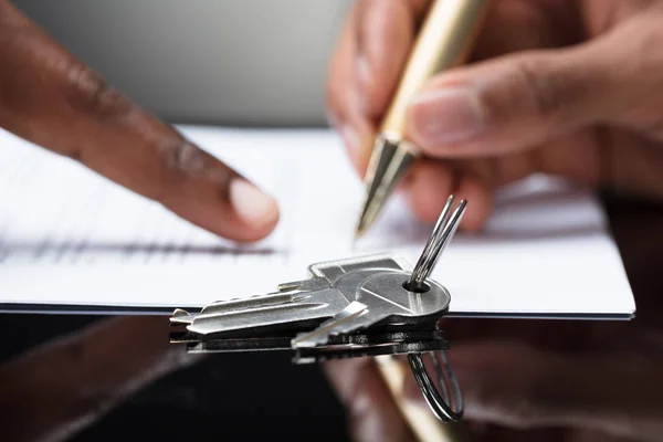 Close Contrato Assinatura Mão Uma Pessoa Com Chaves Nele — Fotografia de Stock