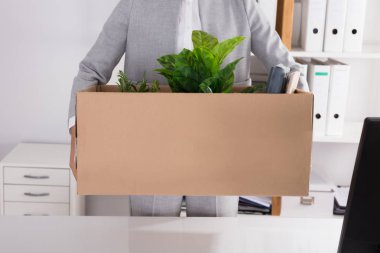 Ofis eşyalarını ile karton kutu taşıyan bir işadamının orta bölüm görünümü