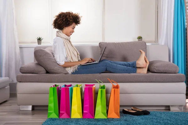 Happy Young Woman Using Laptop Multi Colored Shopping Bags Carpet — стоковое фото