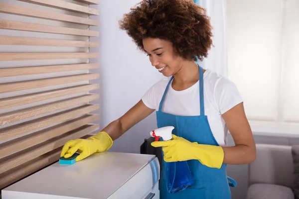 Joven Conserje Sonriente Limpieza Gabinete Blanco Con Esponja — Foto de Stock