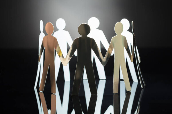 Крупный план вырезания человеческих фигур из бумаги на сером фоне
