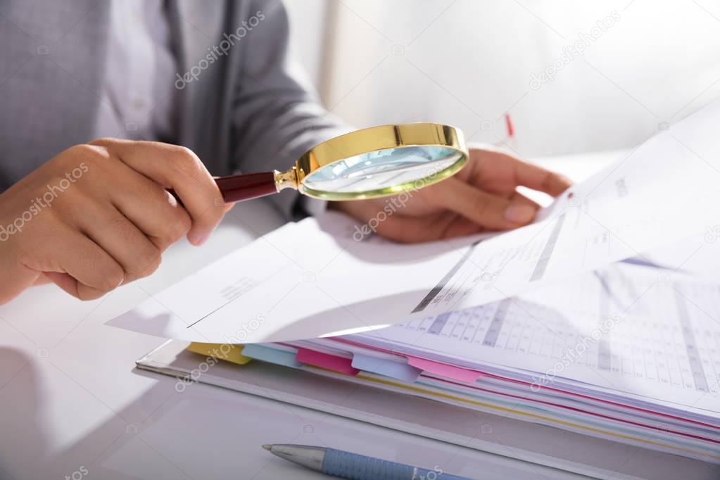 Photo Of Businesswoman Analyzing Invoice With Magnifying Glass