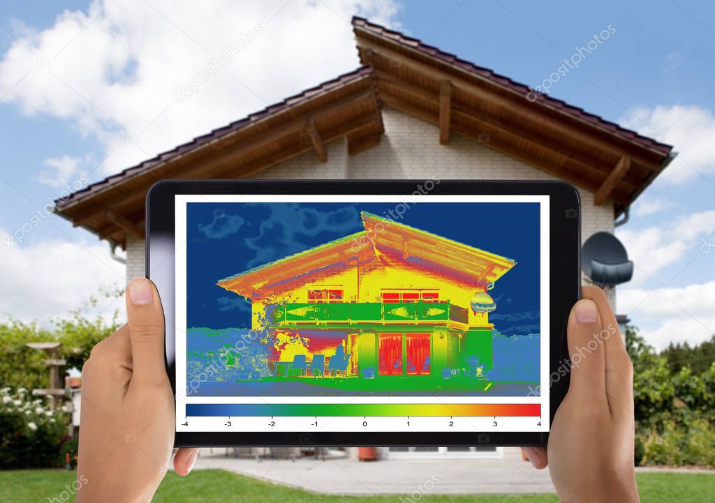 Close-up Of Person Detecting Heat Loss Outside The House Using Digital Tablet