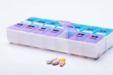Pembe plastik hap Organizer atış ve beyaz arka plan üzerinde tıbbi ilaçlar