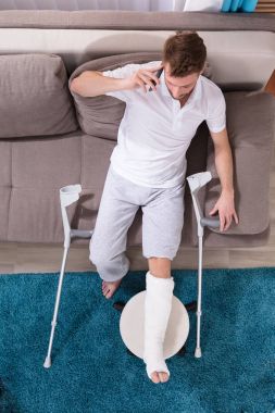 Kırık bacak üstünde hareket eden telefon konuşma ile bir adamın yüksek açılı görünüş