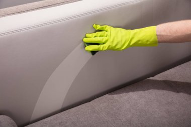 Bir kişinin el Eşyası yakın çekim temizlik kanepe sünger ile eldiven