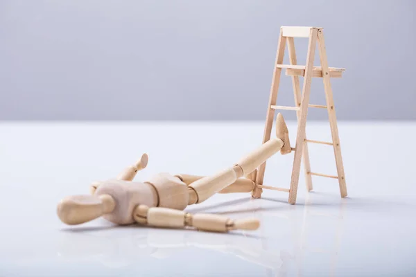 Wooden Figure Lying Floor Falling Ladder — Stock Photo, Image