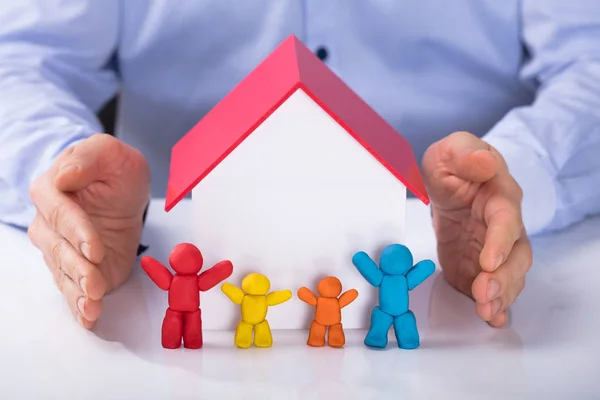 Zbliżenie Dłoni Mężczyzny Ochrona Modelu Dom Kolorowy Rodziny Biurko — Zdjęcie stockowe