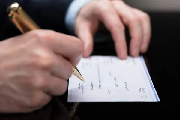 ペンで小切手の署名実業家のクローズ アップ — ストック写真